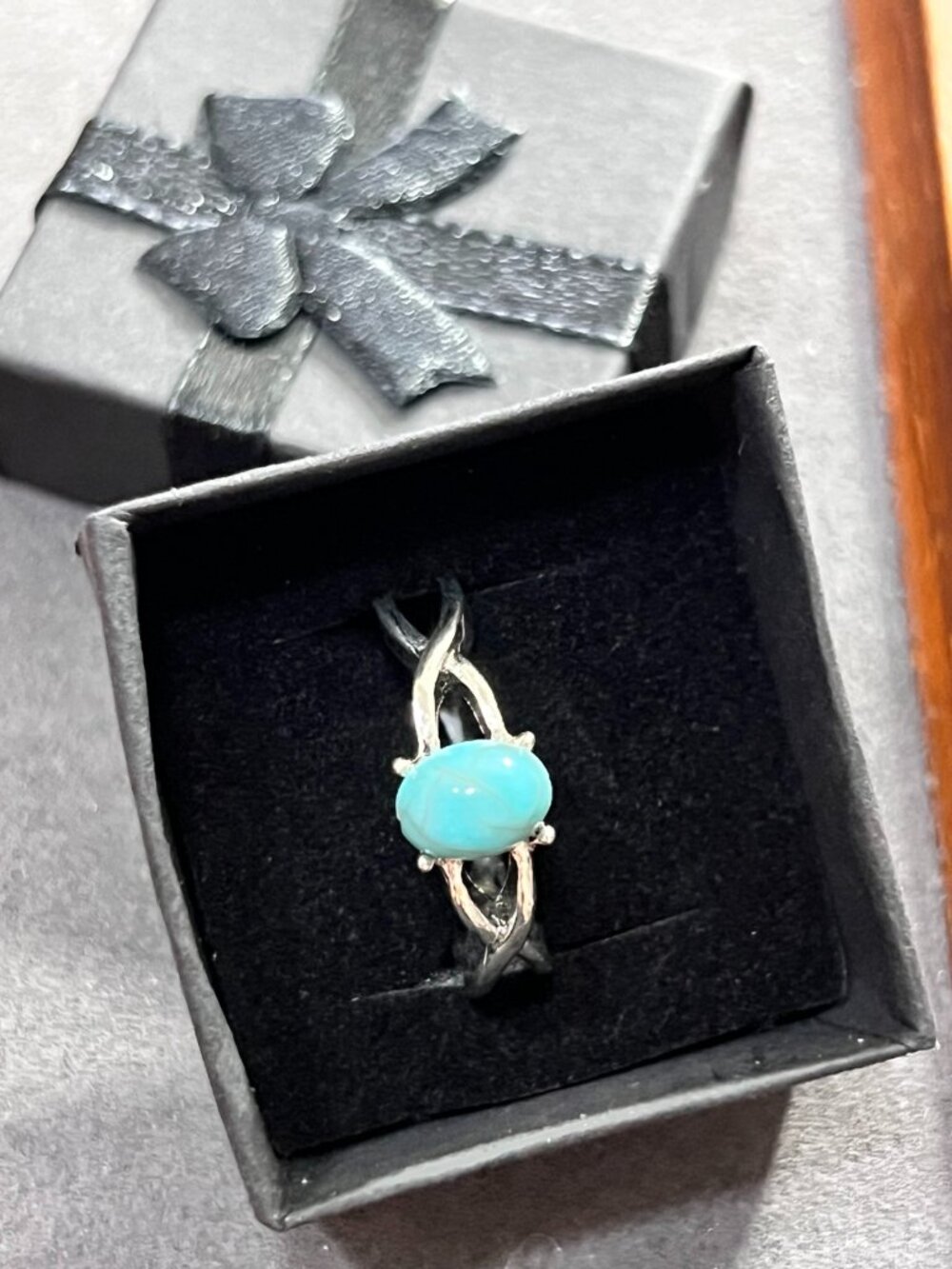 Silver-tone ring featuring an oval turquoise-color cabochon stone like